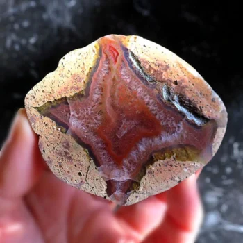 polished rough stone on one side of the palm